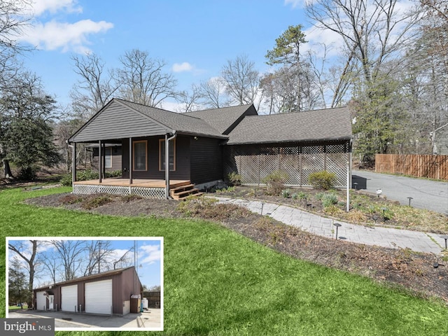 exterior space featuring a garage, fence, a shingled roof, a lawn, and a porch