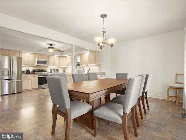 dining area with baseboards, ceiling fan with notable chandelier, and visible vents