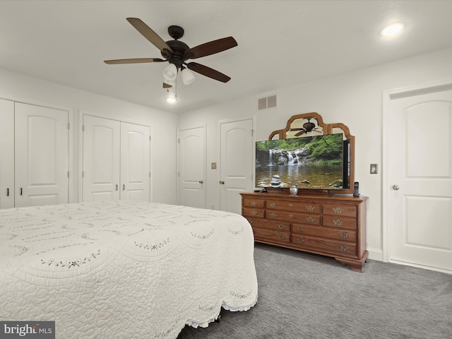bedroom with visible vents, a ceiling fan, multiple closets, and carpet floors