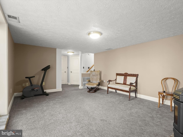 sitting room with a textured ceiling, visible vents, and baseboards