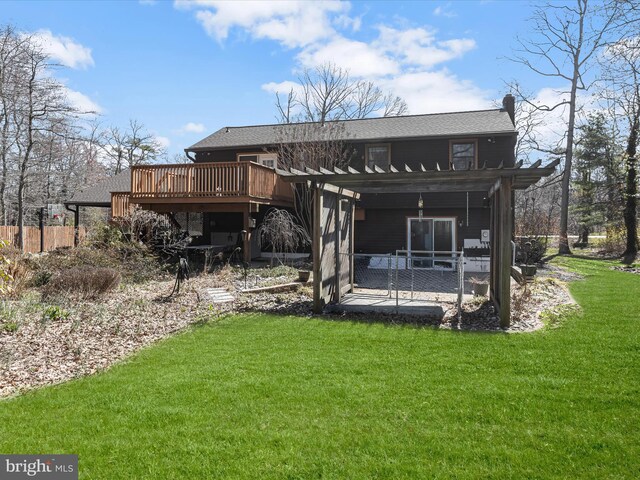 back of property with a lawn, a deck, and a patio