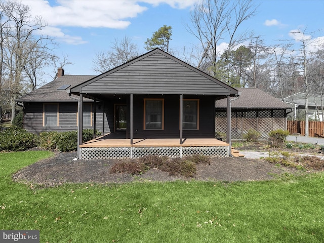 rear view of house with a lawn, a chimney, and a porch