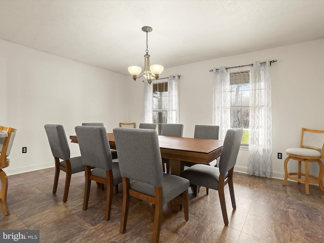 dining room featuring baseboards and an inviting chandelier