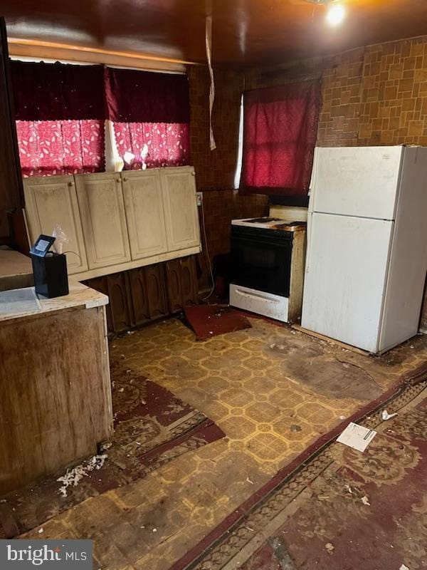 kitchen with freestanding refrigerator and gas stove