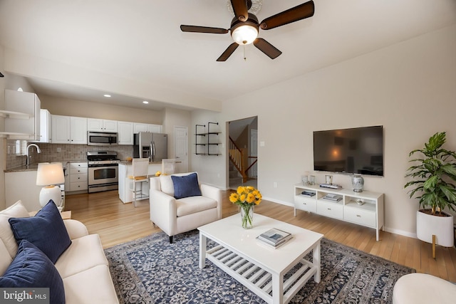 485 Lake George Cir, West Chester, PA 19382 - living room featuring ceiling fan, stairway, light wood-style floors, and baseboards