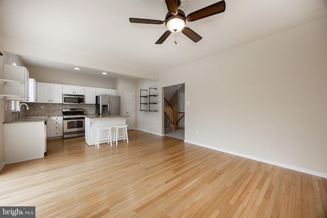 485 Lake George Cir, West Chester, PA 19382 - living area with stairs, light wood-style floors, baseboards, and a ceiling fan