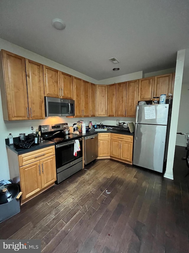 416 N Wiota St, Philadelphia, PA 19104 - kitchen featuring dark wood-style floors, dark countertops, appliances with stainless steel finishes, and a sink
