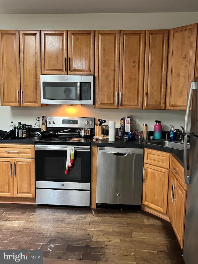 416 N Wiota St, Philadelphia, PA 19104 - kitchen with dark countertops, stainless steel appliances, dark wood-style floors, and brown cabinets