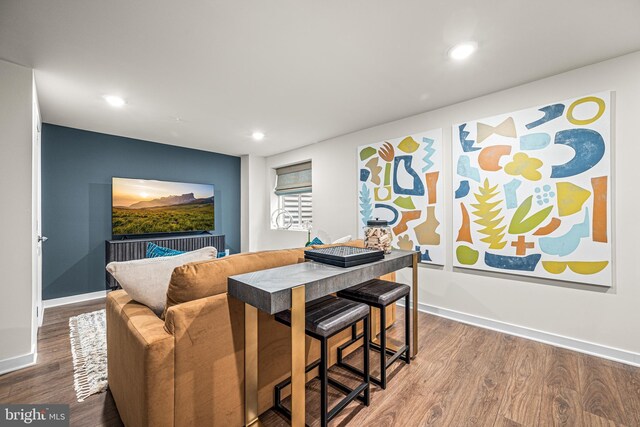 dining area featuring baseboards, wood finished floors, and recessed lighting