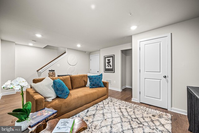 living area featuring visible vents, baseboards, wood finished floors, recessed lighting, and stairway