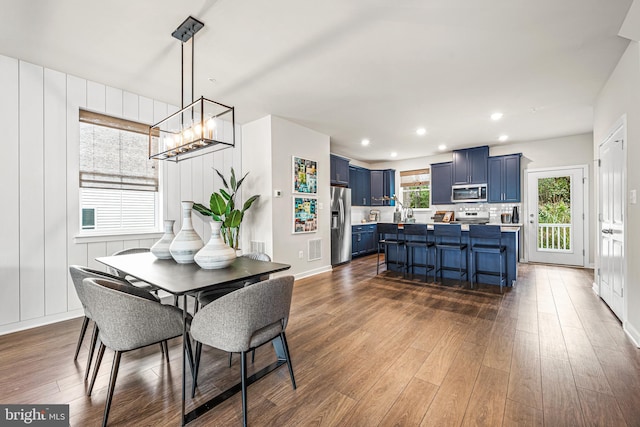 dining space with dark wood-style flooring, an inviting chandelier, and recessed lighting