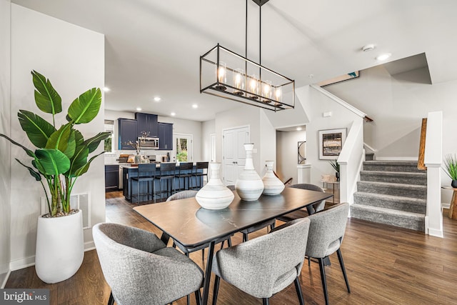dining area featuring dark wood finished floors, baseboards, recessed lighting, and stairway