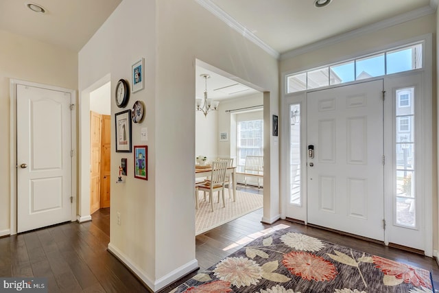 entryway with a notable chandelier, baseboards, crown molding, and dark wood finished floors