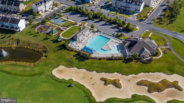 drone / aerial view with view of golf course and a water view