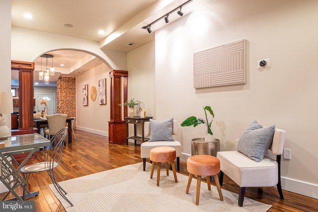 interior space with baseboards, arched walkways, and hardwood / wood-style flooring