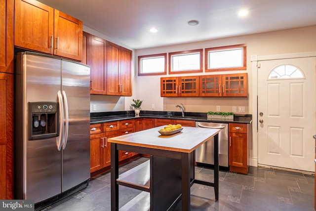 kitchen featuring recessed lighting, dark countertops, a sink, and appliances with stainless steel finishes