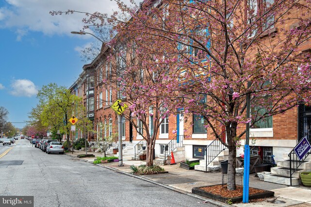 view of road with traffic signs, sidewalks, and curbs