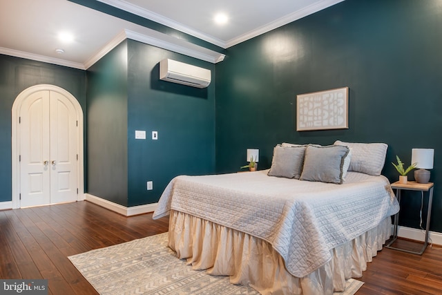 bedroom featuring baseboards, hardwood / wood-style flooring, a wall unit AC, and ornamental molding