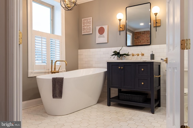 full bathroom featuring vanity, an inviting chandelier, tile patterned floors, a freestanding bath, and tile walls