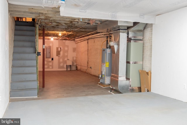 unfinished below grade area featuring gas water heater, electric panel, wood finished floors, stairs, and heating unit