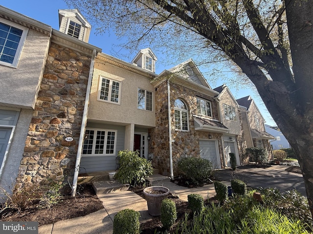 view of front of property featuring stone siding and a garage