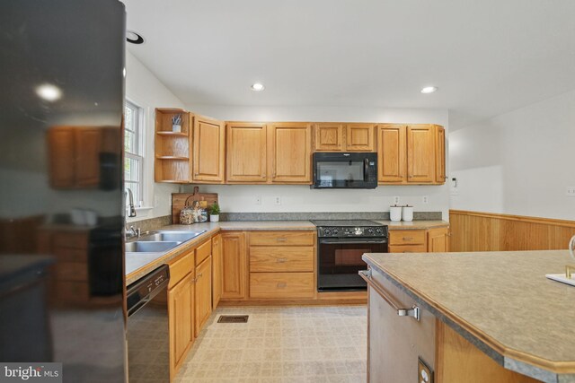 kitchen with open shelves, black appliances, visible vents, wainscoting, and a sink