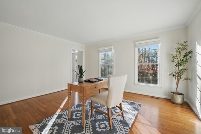 home office with ornamental molding, visible vents, baseboards, and light wood finished floors