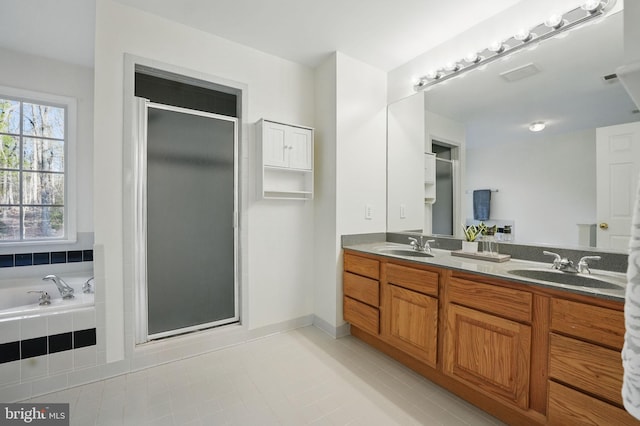 full bath featuring a sink, tile patterned flooring, a shower stall, and double vanity