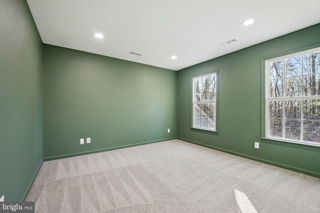 carpeted spare room featuring visible vents and recessed lighting