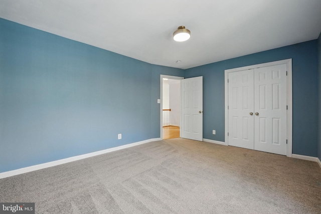 unfurnished bedroom with carpet floors, baseboards, and a closet
