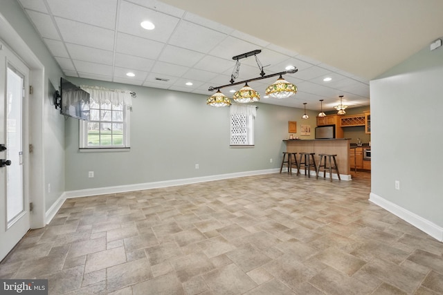 interior space with baseboards, recessed lighting, visible vents, stone finish flooring, and a drop ceiling