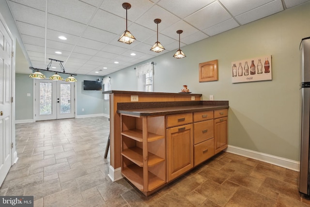 kitchen with a peninsula, baseboards, open shelves, and a drop ceiling