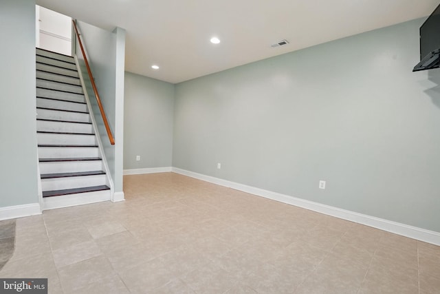 below grade area featuring recessed lighting, baseboards, visible vents, and stairs