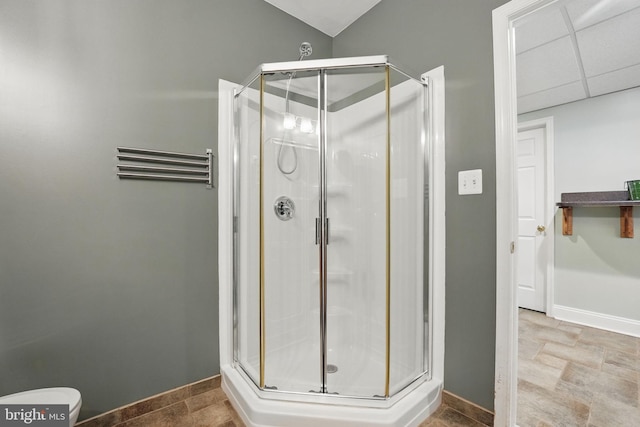 bathroom featuring a shower stall and baseboards
