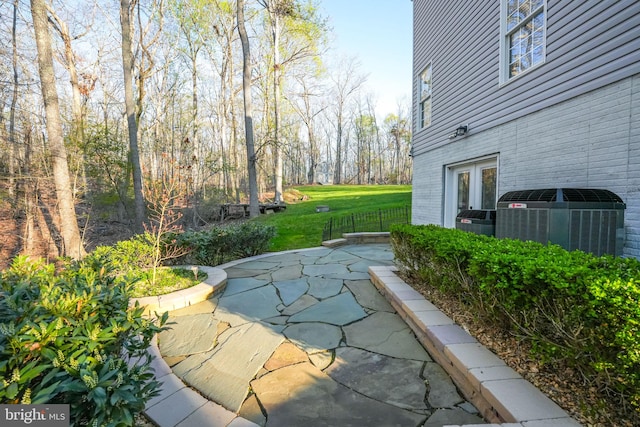 view of yard featuring a patio area, central air condition unit, and french doors