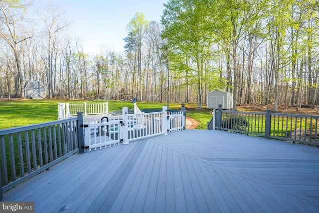 deck featuring an outbuilding, a lawn, and a storage unit