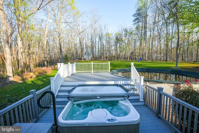 wooden deck featuring area for grilling, a covered hot tub, and a lawn