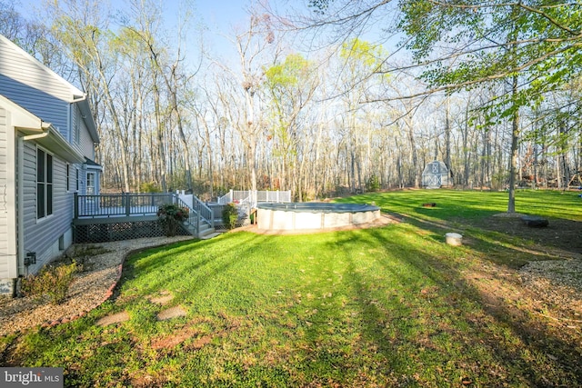 view of yard with a wooden deck and a covered pool