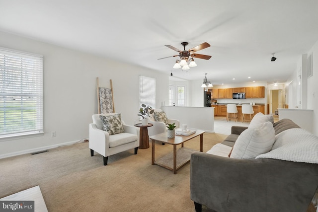living room with visible vents, baseboards, a ceiling fan, recessed lighting, and light carpet