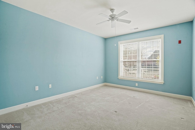 empty room with a ceiling fan, visible vents, and carpet