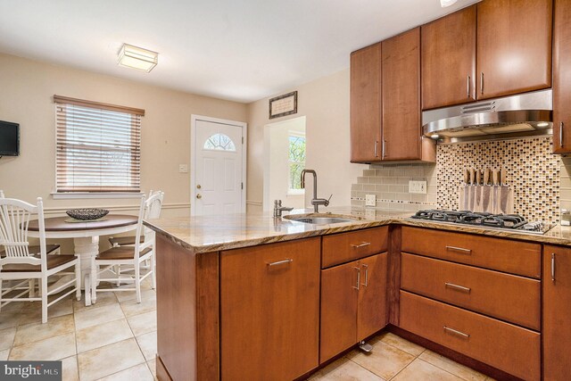 1057 Fitzwatertown Rd, Roslyn, PA 19001 - kitchen featuring a sink, a peninsula, under cabinet range hood, brown cabinets, and light stone countertops