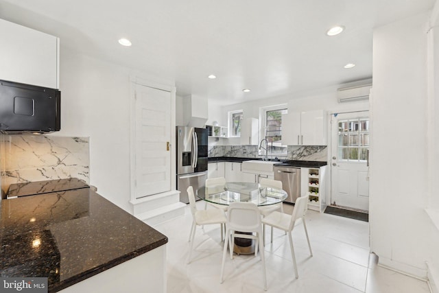 251 S 46th St, Philadelphia, PA 19139 - kitchen with recessed lighting, a sink, white cabinets, tasteful backsplash, and appliances with stainless steel finishes