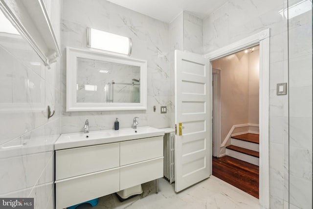 251 S 46th St, Philadelphia, PA 19139 - bathroom with tile walls, marble finish floor, radiator heating unit, a sink, and double vanity