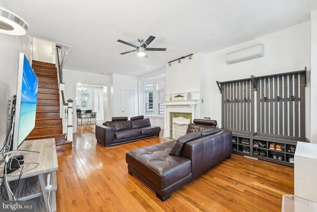 251 S 46th St, Philadelphia, PA 19139 - living room featuring a ceiling fan, a fireplace, hardwood / wood-style flooring, an AC wall unit, and stairs