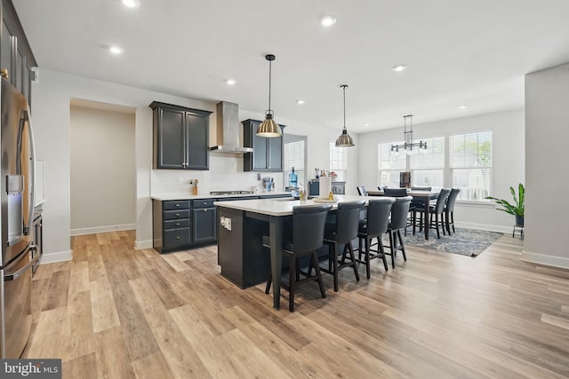 131 Boxelder Dr, Stafford, VA 22554 - kitchen with baseboards, a kitchen bar, light wood finished floors, wall chimney exhaust hood, and stainless steel fridge with ice dispenser