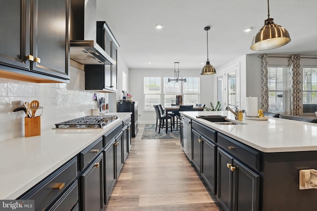 131 Boxelder Dr, Stafford, VA 22554 - kitchen featuring wall chimney range hood, a sink, appliances with stainless steel finishes, light wood-style floors, and light countertops