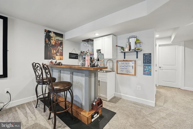 131 Boxelder Dr, Stafford, VA 22554 - bar with light colored carpet, bar, a sink, and baseboards