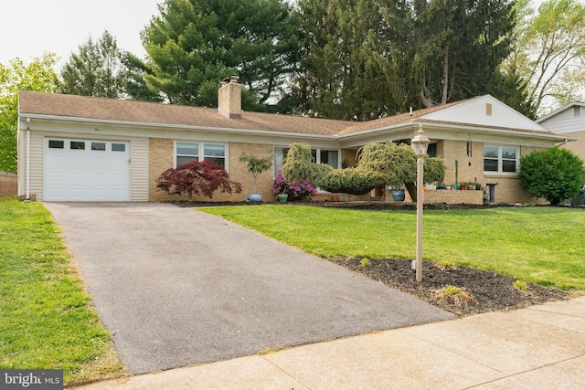 ranch-style house featuring a front lawn, a chimney, brick siding, an attached garage, and driveway