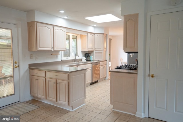 kitchen featuring a skylight, cooktop, stainless steel dishwasher, and light tile patterned flooring