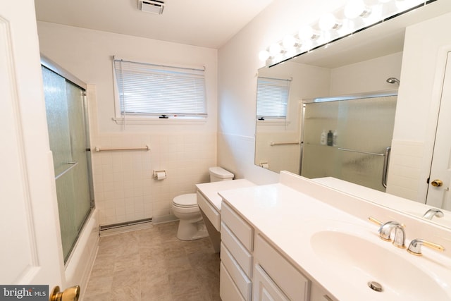 full bathroom featuring baseboard heating, vanity, toilet, tile walls, and visible vents